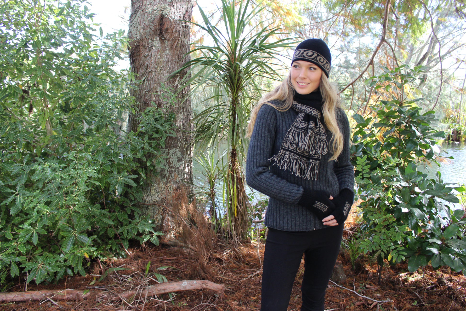 A unisex scarf knitted in double thickness with a koru patterned edging. A long scarf that is reversible and has two tone fringing. Approx. 19cm x 154cm long with 7cm fringe. Made in NZ by Lothlorian. Black.