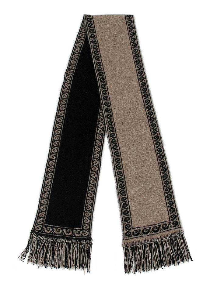 A unisex scarf knitted in double thickness with a koru patterned edging. A long scarf that is reversible and has two tone fringing. Approx. 19cm x 154cm long with 7cm fringe. Made in NZ by Lothlorian. Black.