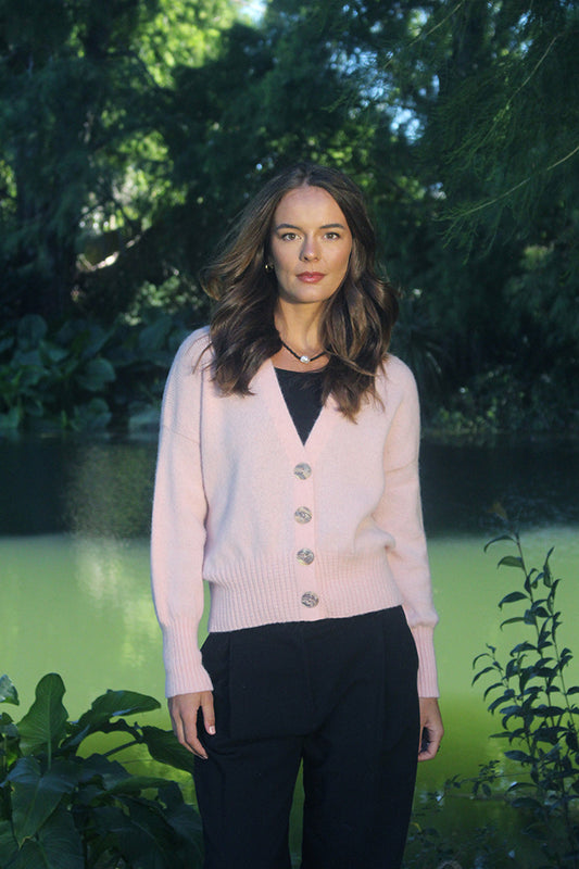 Made from Baby Alpaca yarn the beautiful Enclave Cardigan, is a relaxed style with a deep V neckline. Shell buttons compliment this delicate shade of Blush. With a shorter length - finishing on the hip - it is a perfect layering garment. Sizes: S-2XL.