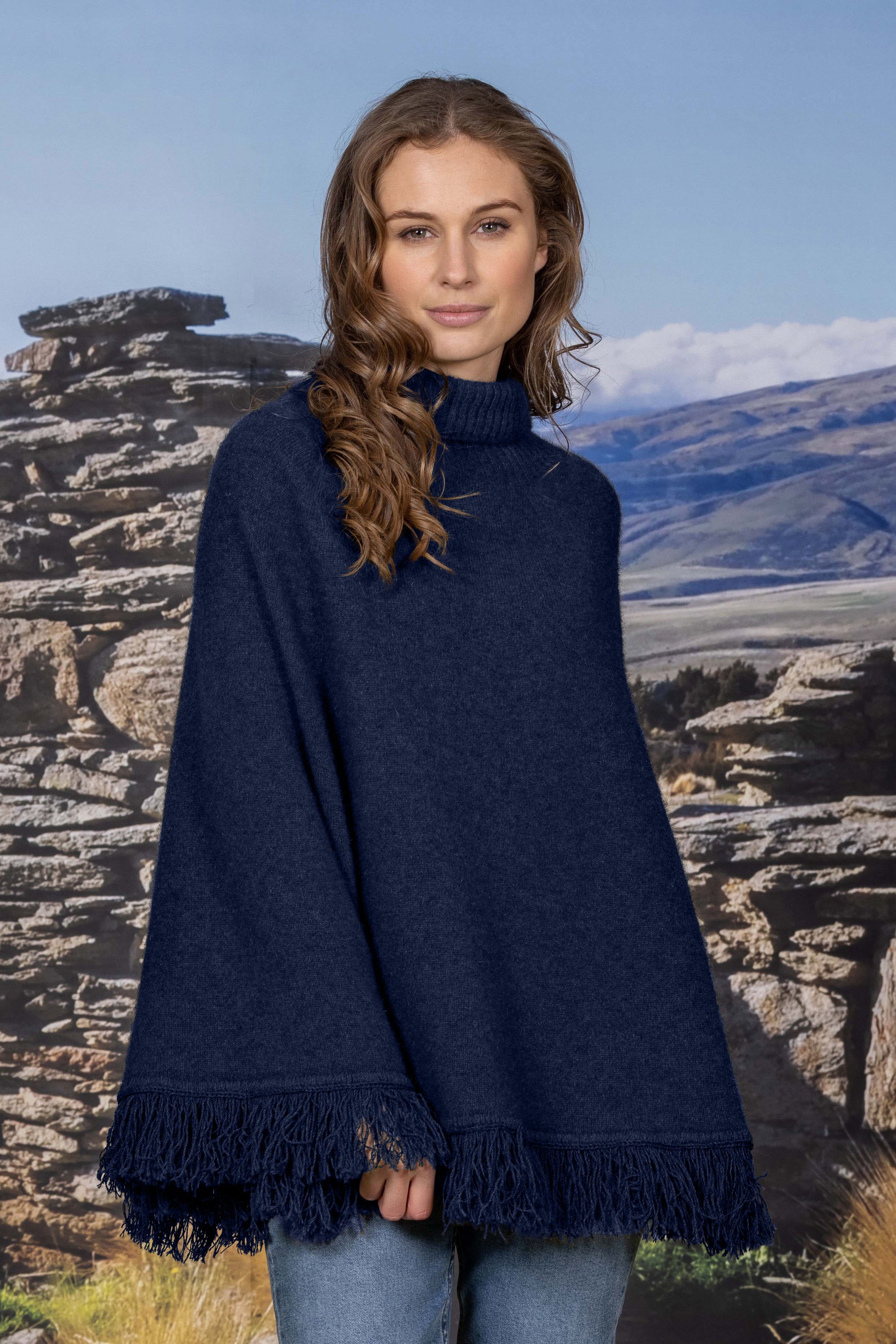 Stunning for any occasion this classic possum merino poncho has a stylish polo neck for extra warmth and with the fringed binding around the hem takes you on a visual trip back to the 70's!! Drapes beautifully. Made in Christchurch, NZ by Noble Wilde. Maritime.