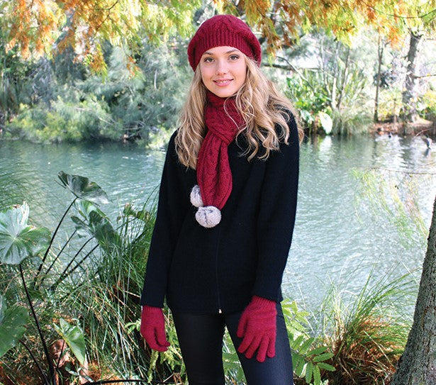 A relaxed cable beanie with rabbit fur pom pom. Colour - raspberry with grey pom pom.