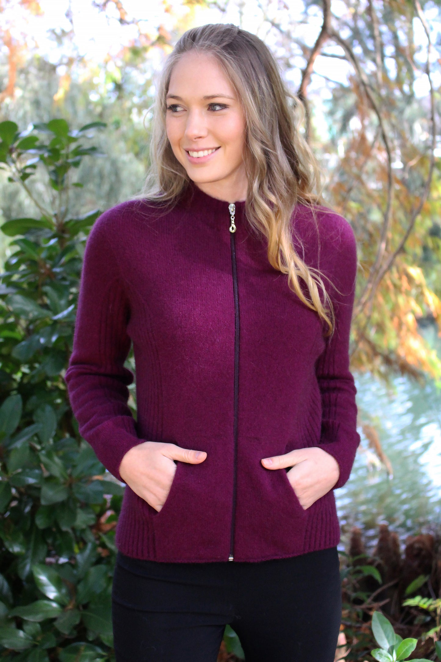 A flattering but practical style jacket. Rib details on the side panels add a little shape, has a full zip and seamless pockets. Available in sizes XS, S, M, L, XL, XXL. Made in NZ from a possum merino blend by Lothlorian. Berry.