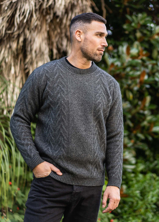 A crew neck style featuring a textured Aran pattern on the front and sleeves with a ribbed crew neckline. Made by Koru Knitwear, NZ.