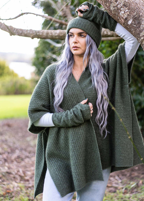 A great "throw on and go" piece to add to your collection. This fabulous cape has a small seam to form a loose and practical arm hole. In a detailed zig zag pattern, you can dress this cape up or down to suit any occasion. Made in Warkworth, NZ by Koru Knitwear. Moss.