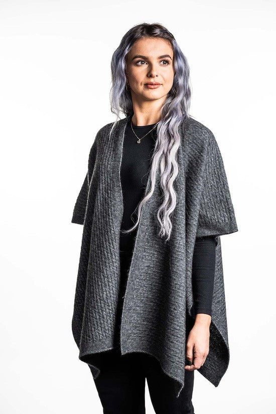 A great "throw on and go" piece to add to your collection. This fabulous cape has a small seam to form a loose and practical arm hole. In a detailed zig zag pattern, you can dress this cape up or down to suit any occasion. Made in Warkworth, NZ by Koru Knitwear. Grey.