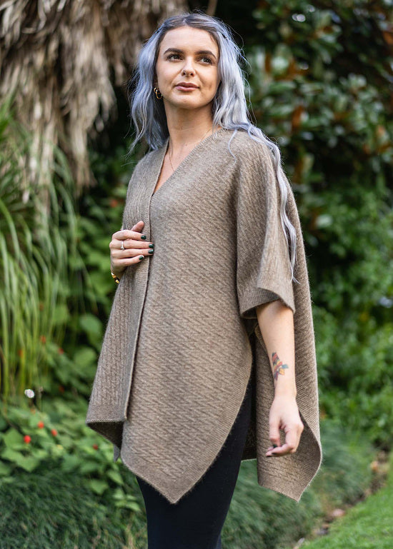 A great "throw on and go" piece to add to your collection. This fabulous cape has a small seam to form a loose and practical arm hole. In a detailed zig zag pattern, you can dress this cape up or down to suit any occasion. Made in Warkworth, NZ by Koru Knitwear. Mocha.