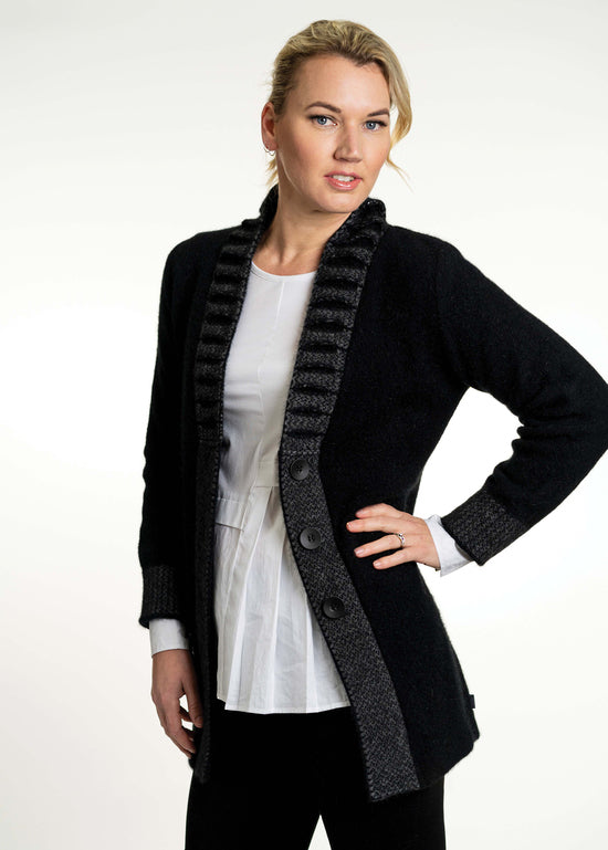 This stunning possum merino button jacket has a unique feature collar with strong vertical lines. A longline jacket that is extremely warm and cosy but is still very flattering to wear. Available in Black/Grey in sizes XS - XXL. Made by Koru in Warkworth, NZ. Black/Grey.