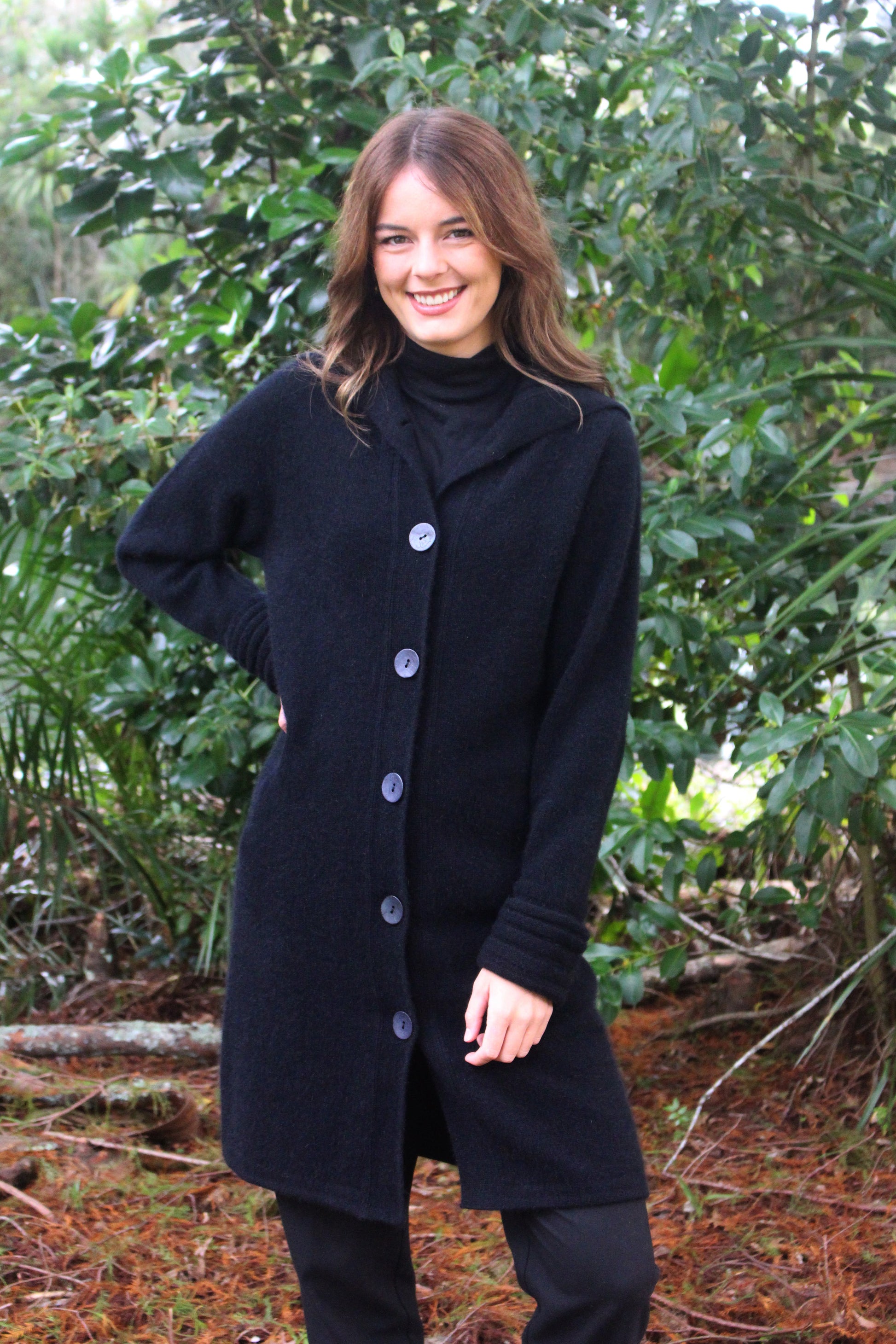 A heavier weight long coat in a possum merino blend. Has V-shaped rib detail at the collar and roll back cuffs with button through fastening. In black only and sizes S, M, L, XL, XXL. Made in NZ by Lothlorian for their Zinity Collection. 