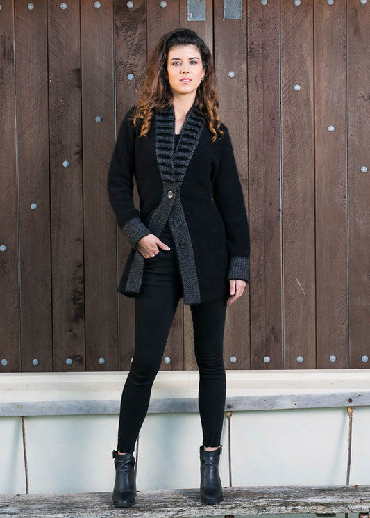 This stunning possum merino button jacket has a unique feature collar with strong vertical lines. A longline jacket that is extremely warm and cosy but is still very flattering to wear. Available in Black/Grey in sizes XS - XXL. Made by Koru in Warkworth, NZ. Black/Grey.
